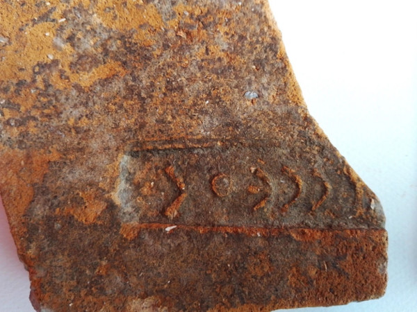 Fragment of a stamped tile, with part of the name of Odysseus